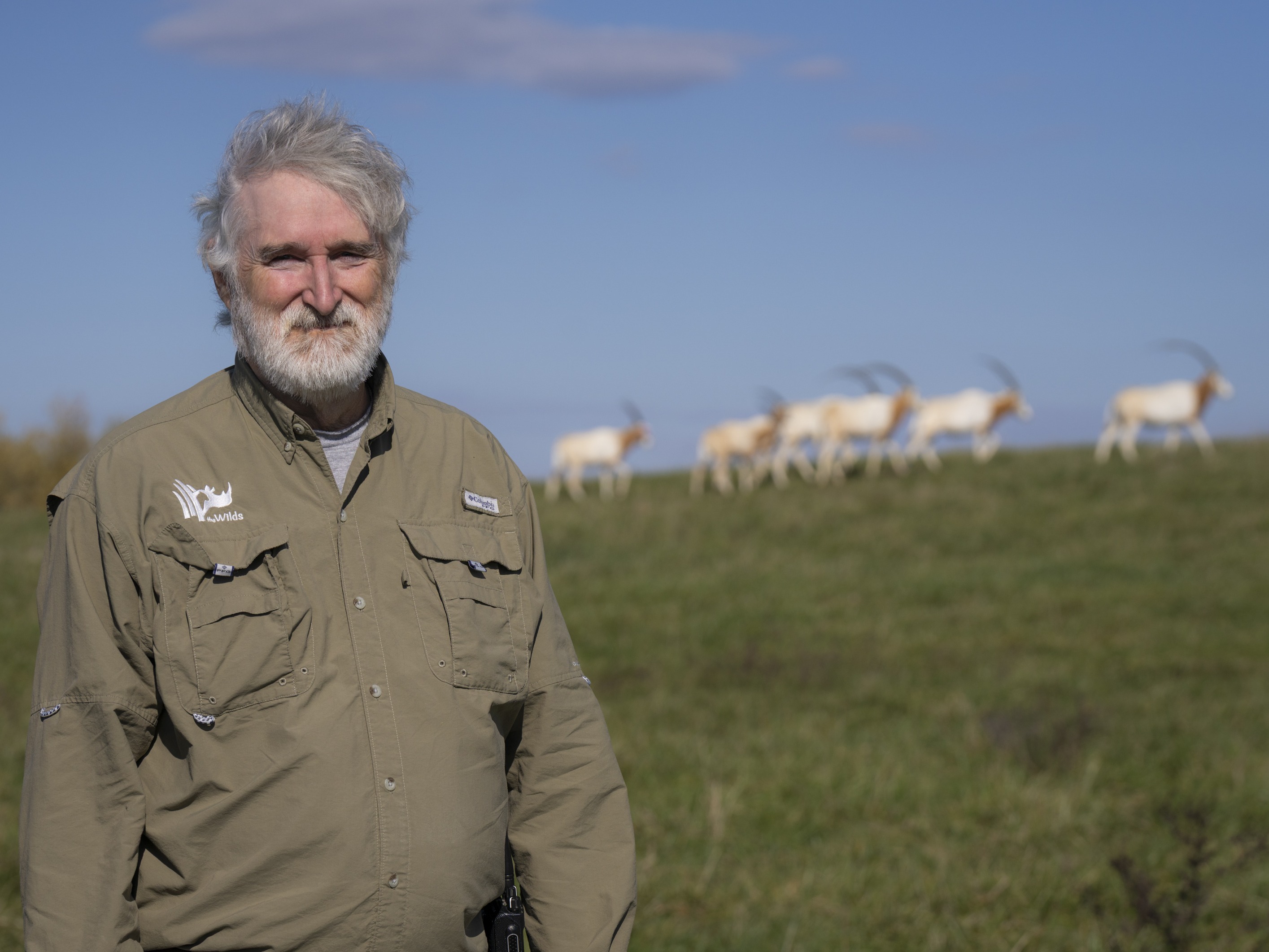employee at The Wilds posing for photo in front of oryx