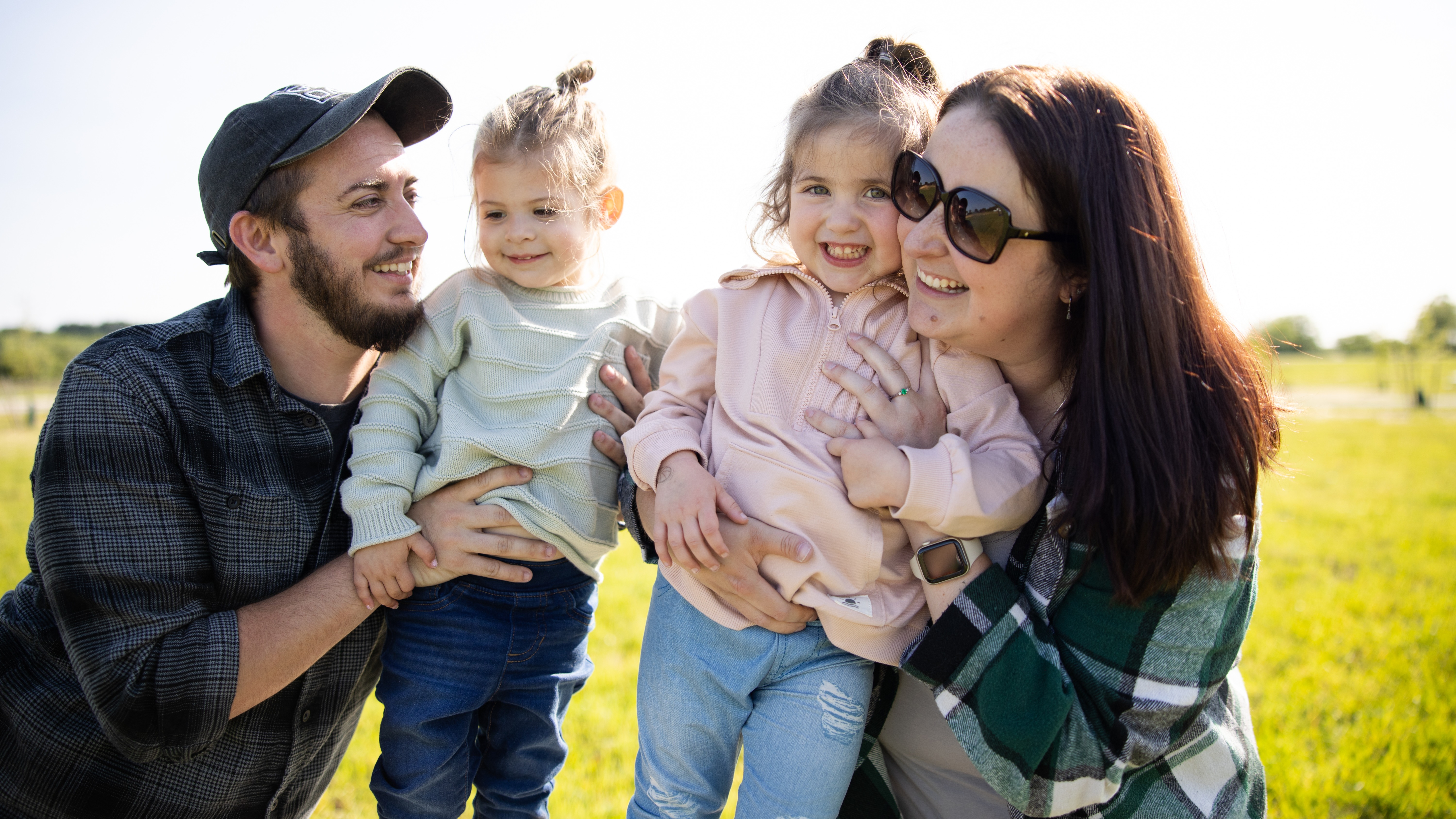 family laughing while sitting on ground