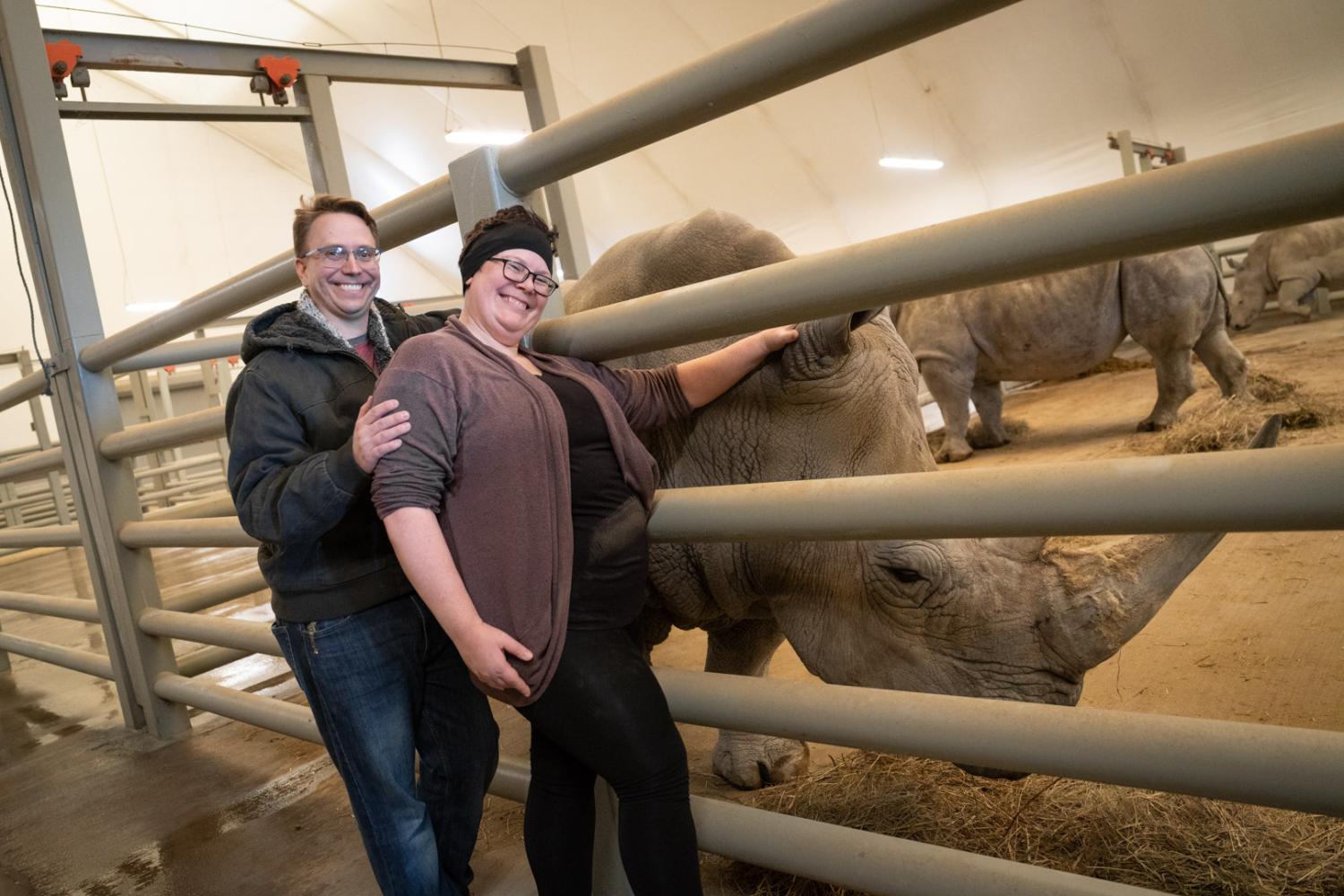 man and woman posing with rhino