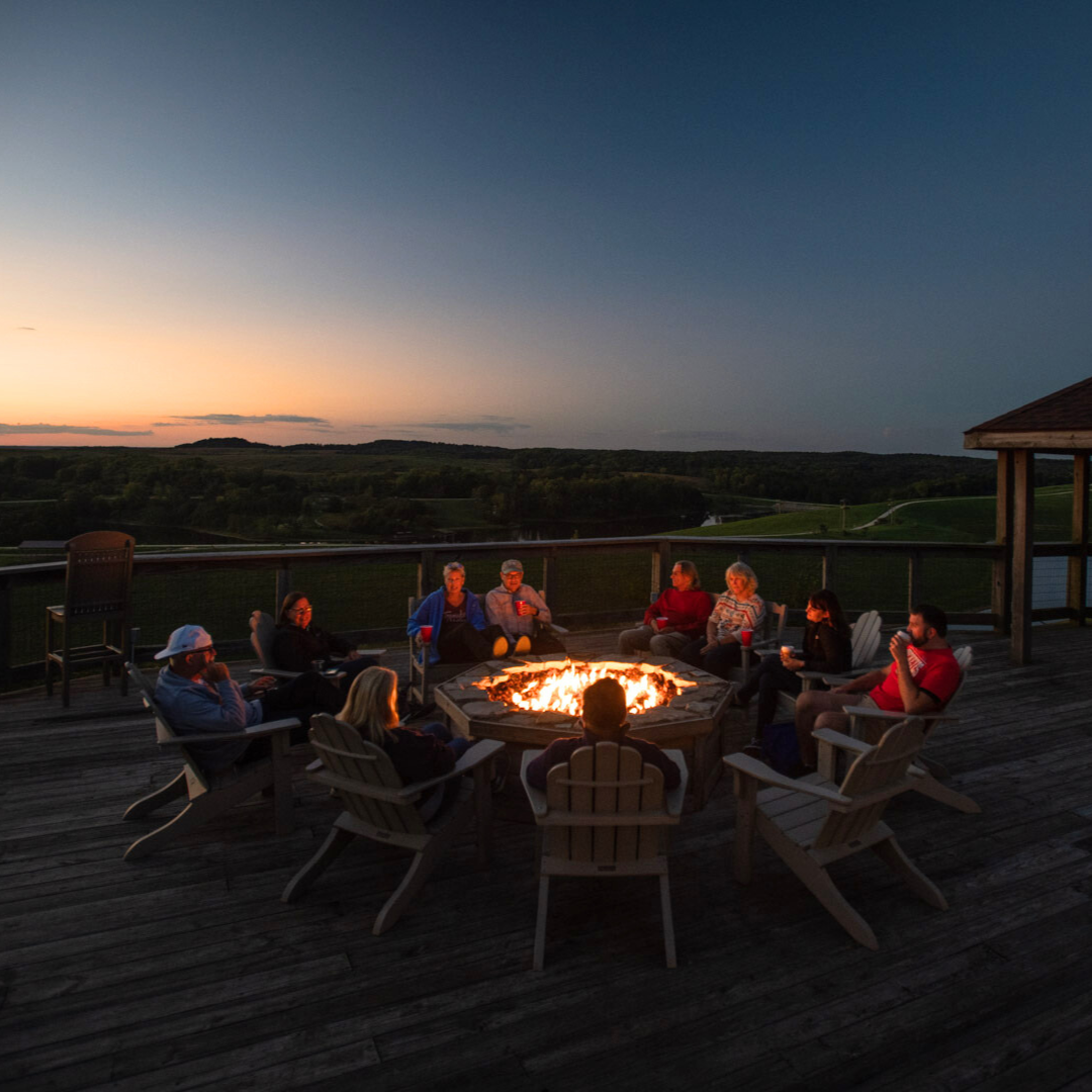 people sitting around a fire ring 