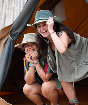 two individuals laughing in tent