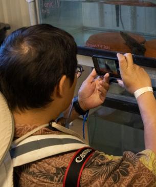man taking picture of hellbender