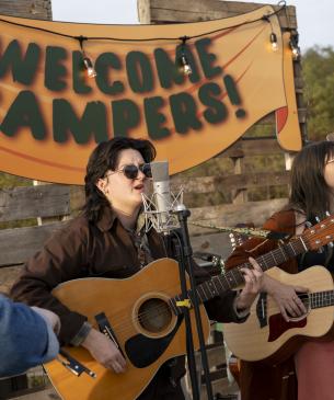 Band playing with Welcome Campers sign behind them