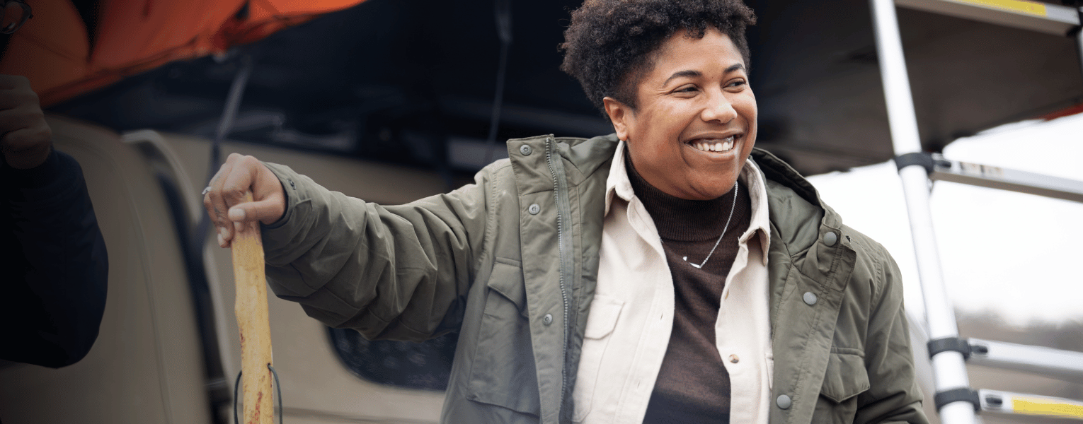 woman smiling next to camper